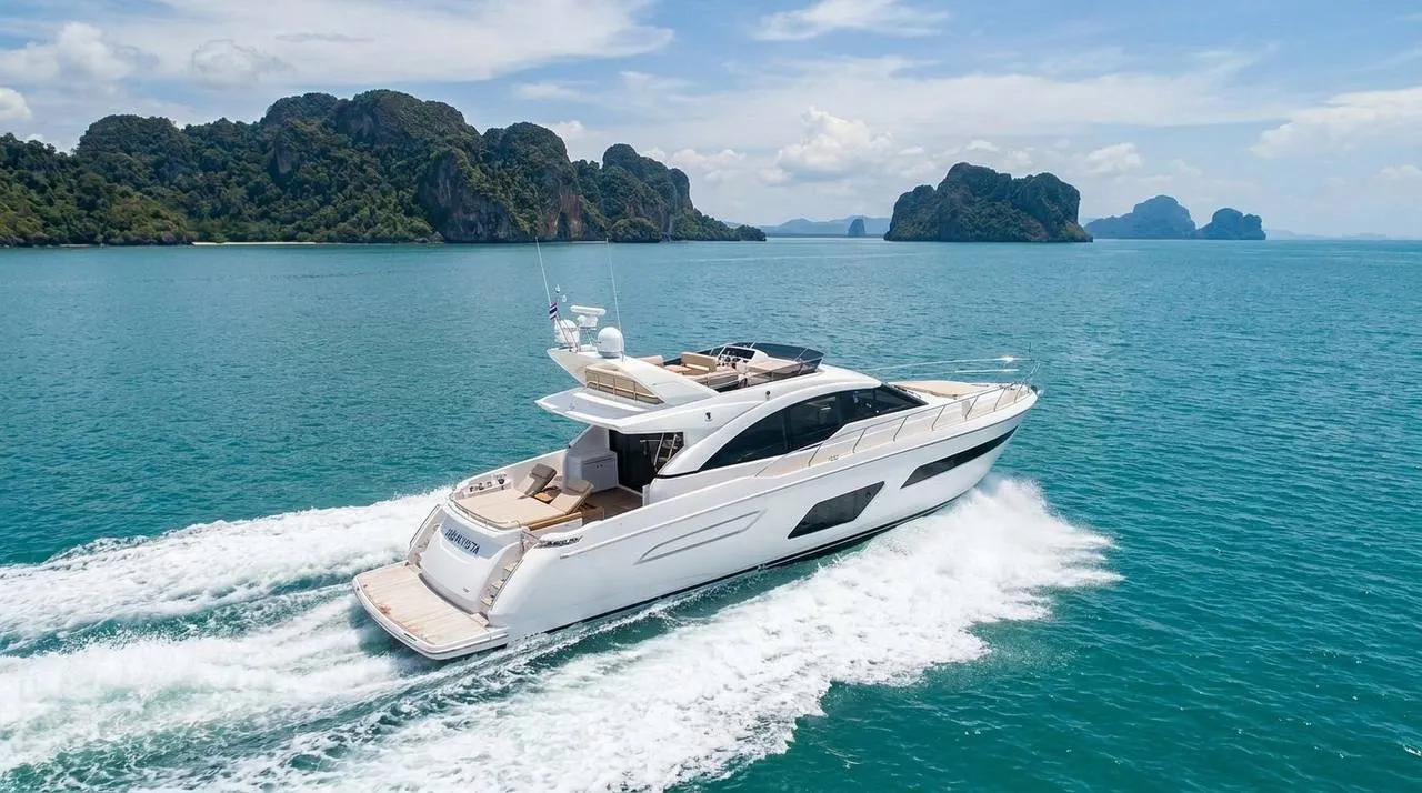Motor yacht cruising past limestone islands on a long-distance route from Phuket